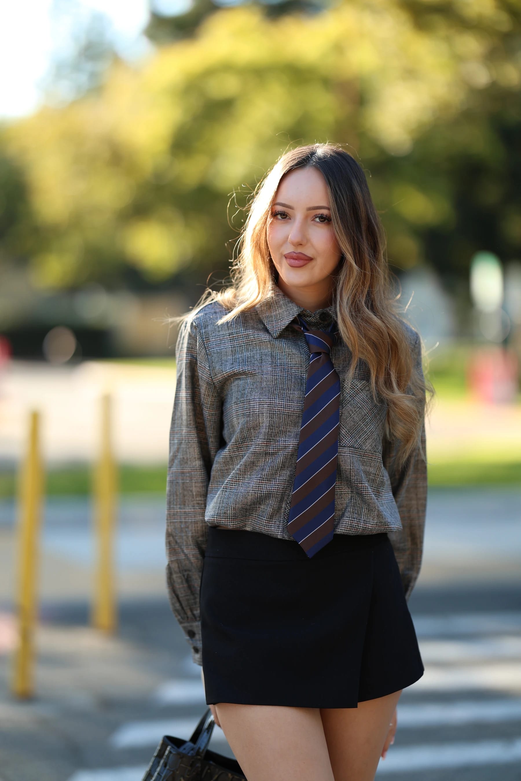 Andrea half body in a plaid shirt and tie by the bollards — photo B