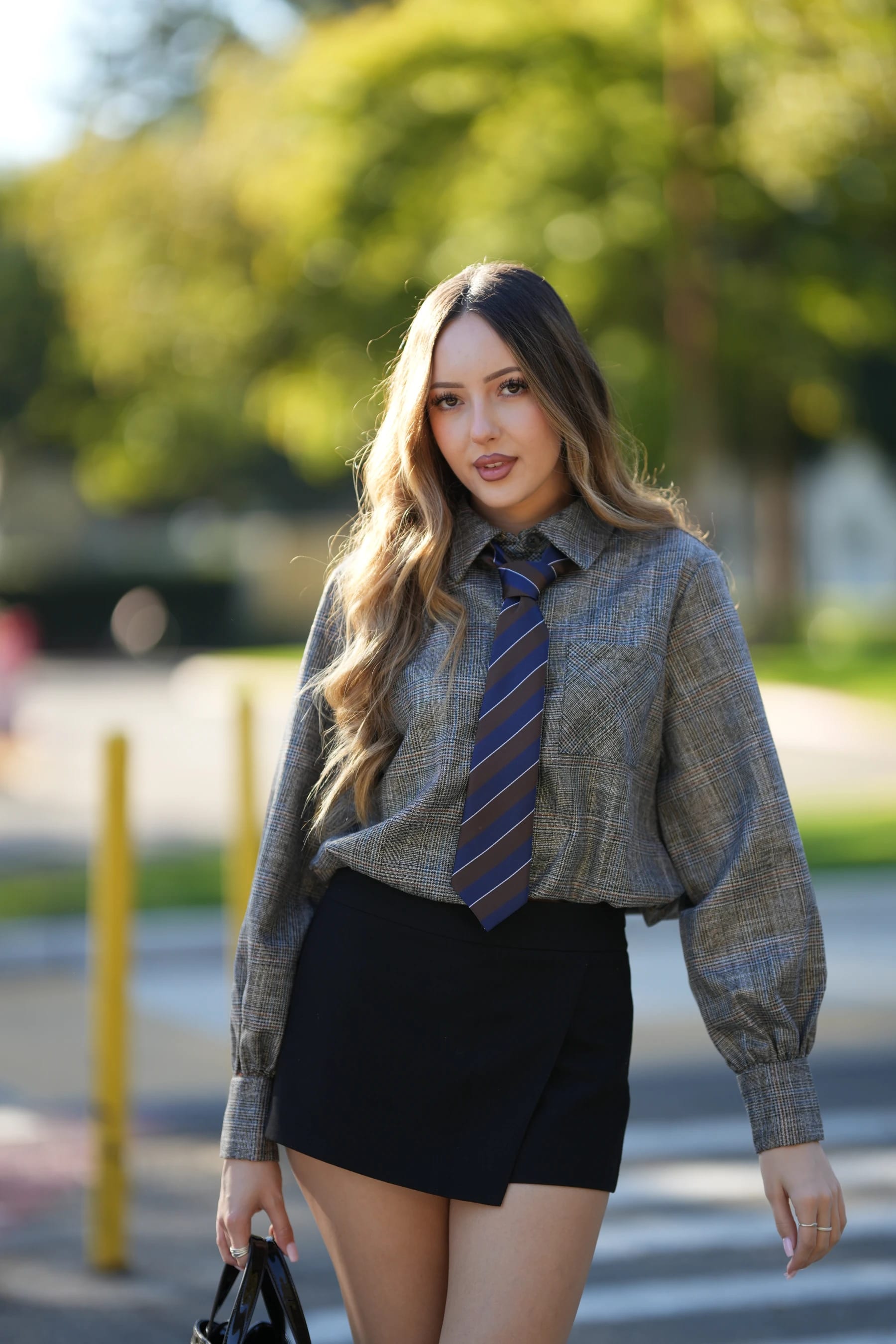 Andrea half body in a plaid shirt and tie by the bollards — photo A