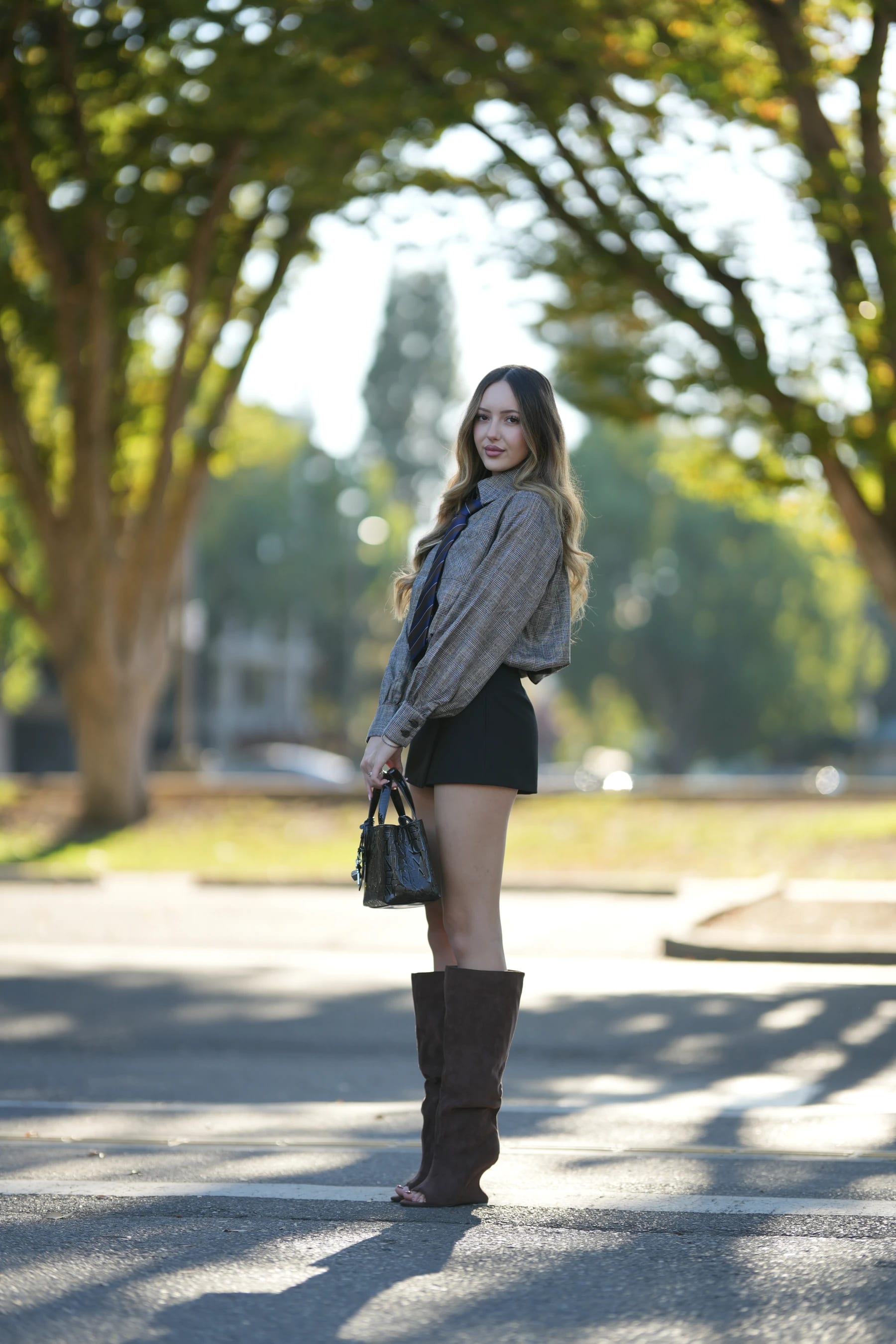 Andrea full length on a tree-lined road in backlight — photo B