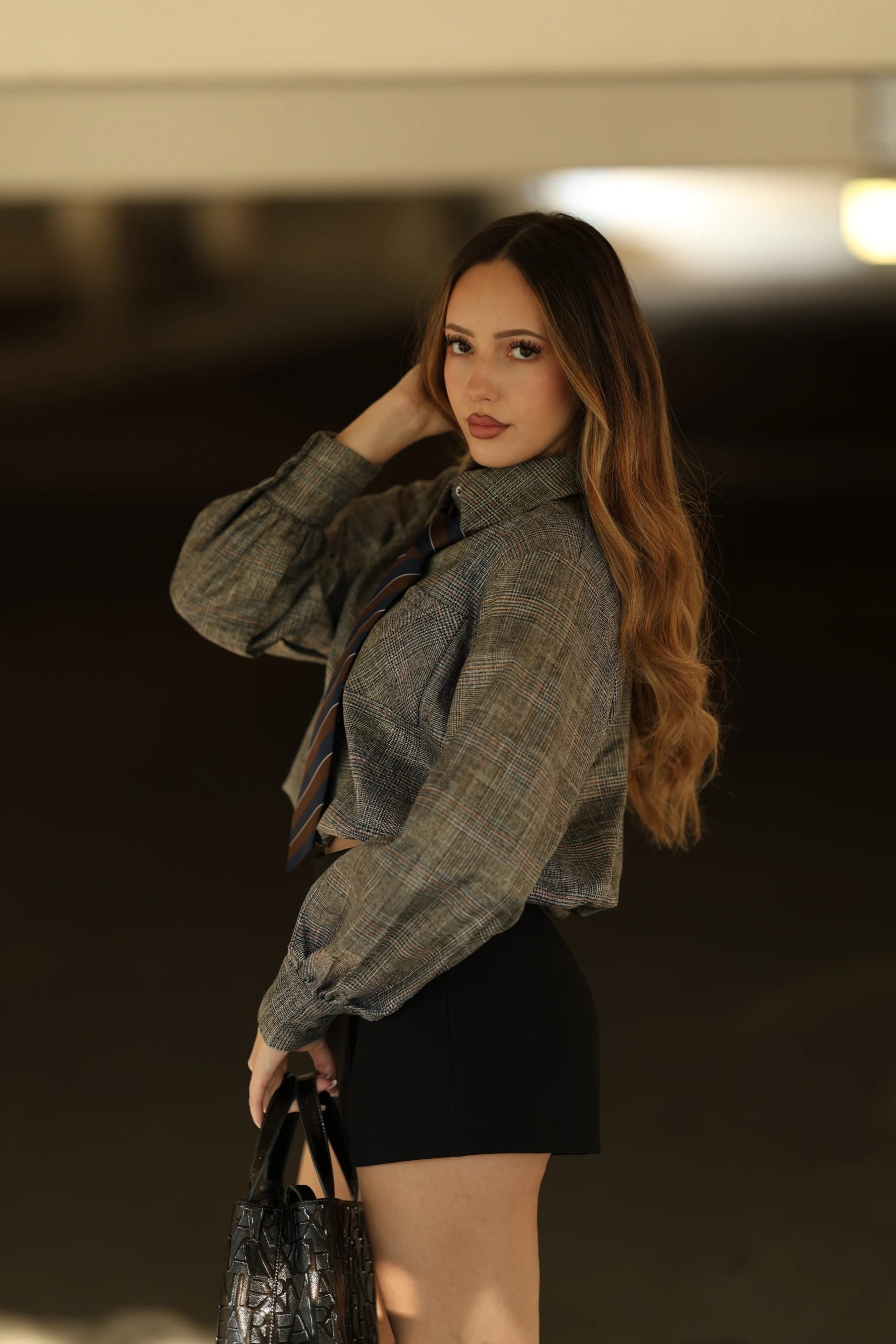 Andrea half body looking back in a parking garage — photo A