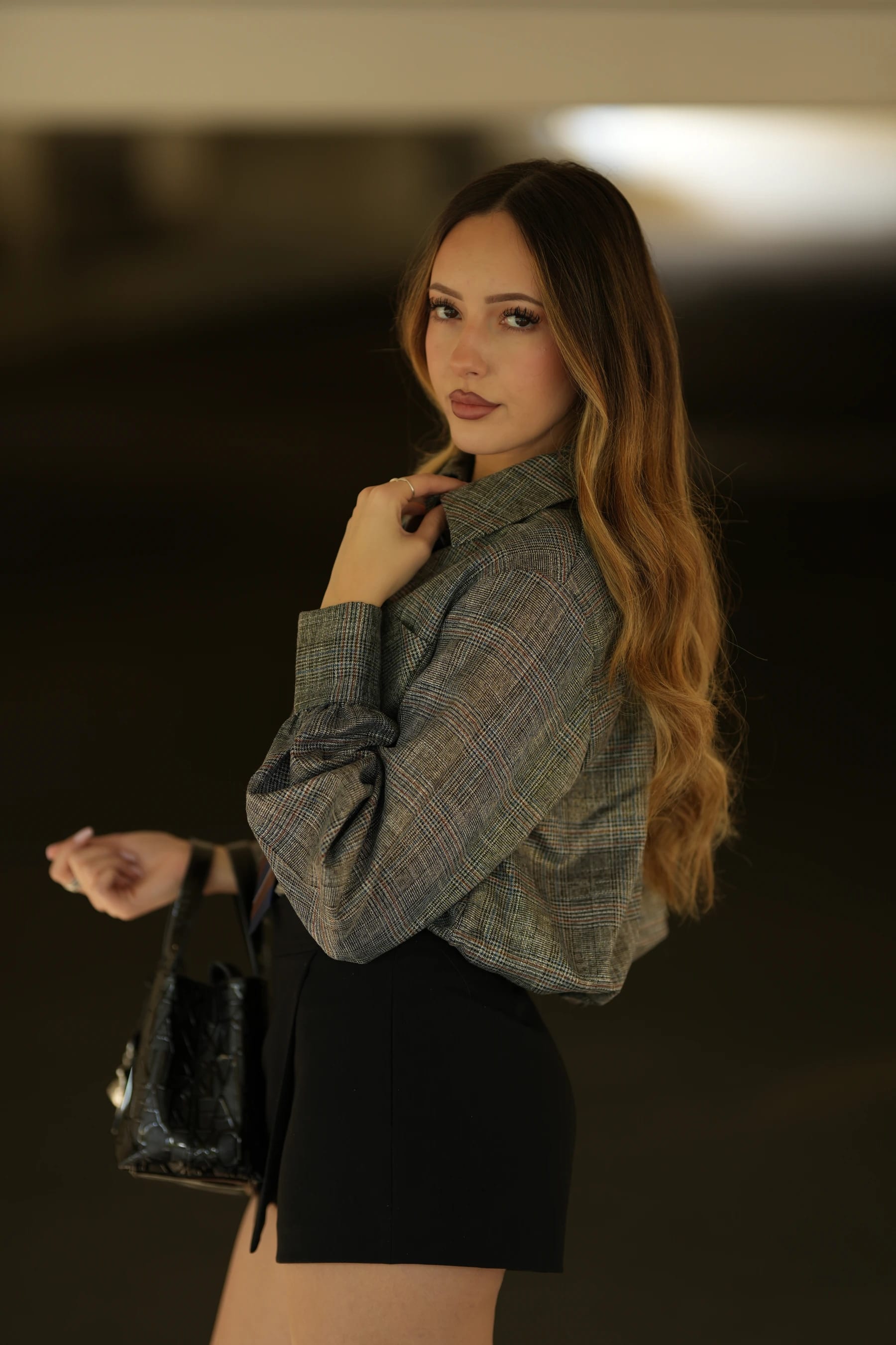 Andrea half body looking back in a parking garage — photo B