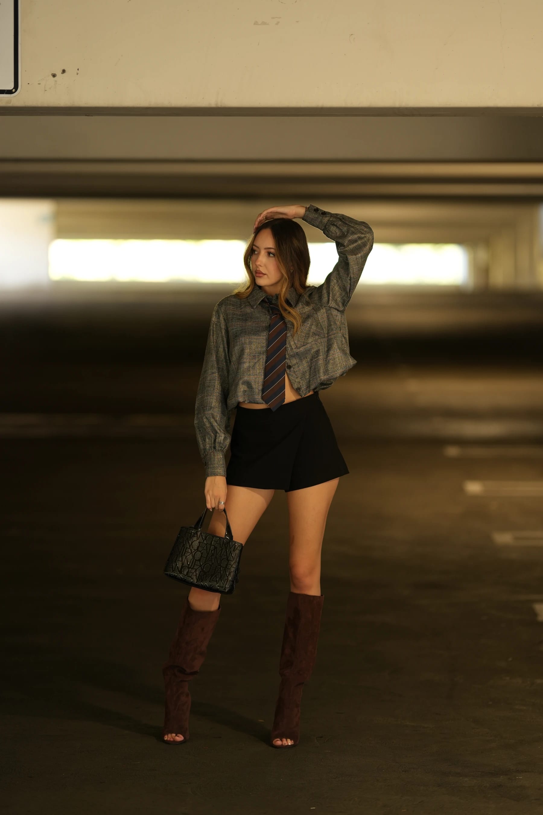 Andrea with a hand in her hair under the garage lights — photo A