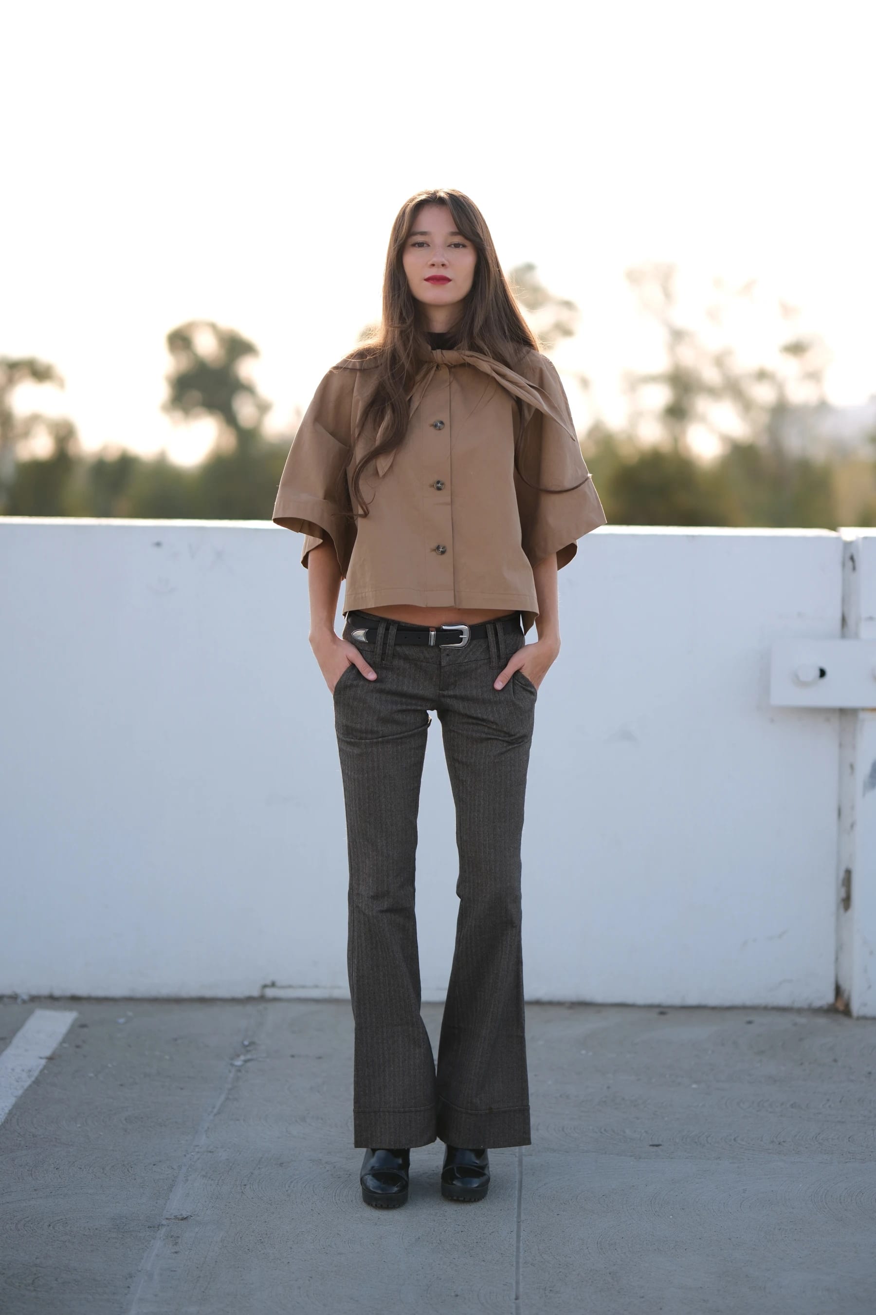 Rosina full length against a white rooftop wall — photo B