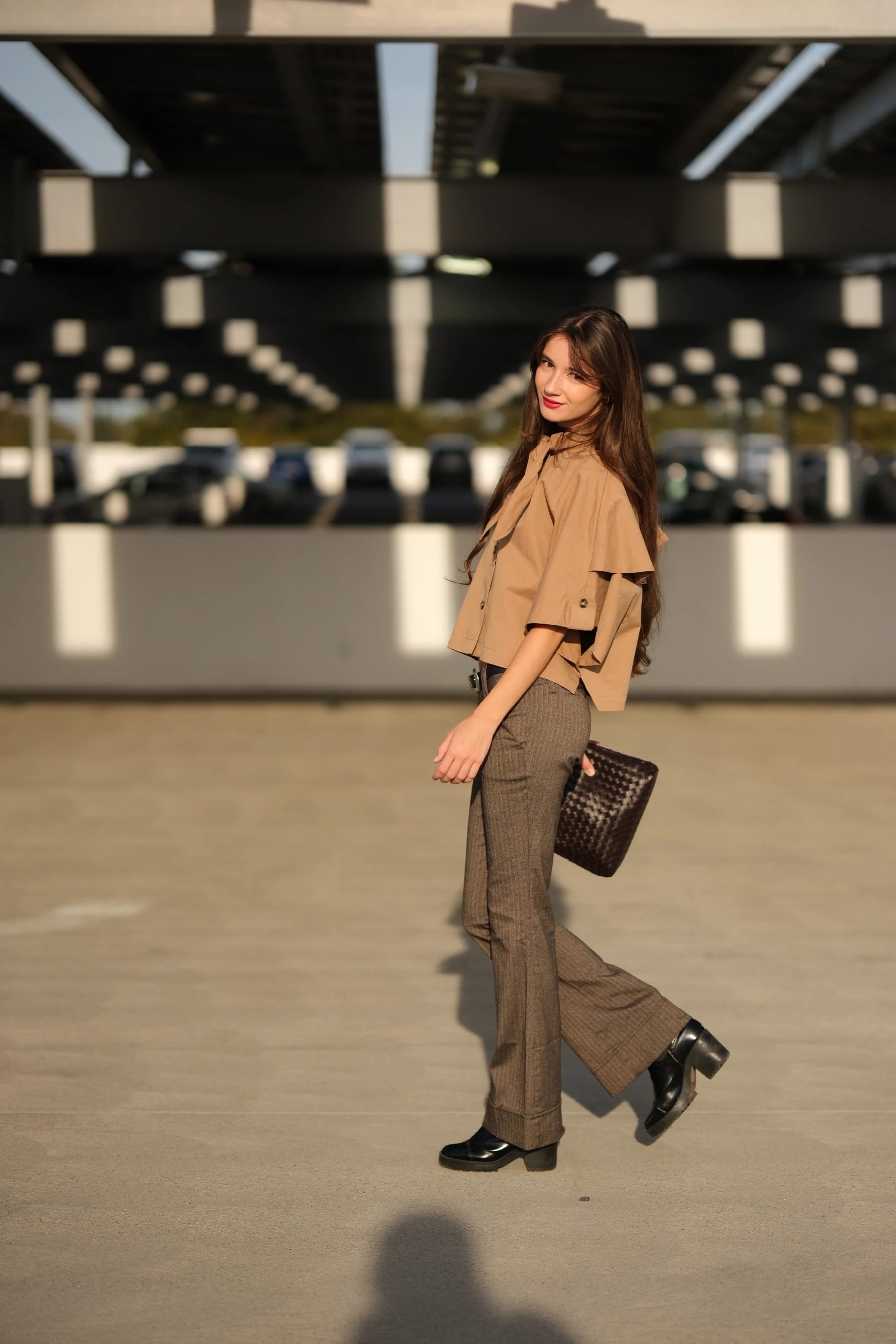 Rosina walking across the garage floor with her bag, looking back over her shoulder — photo A