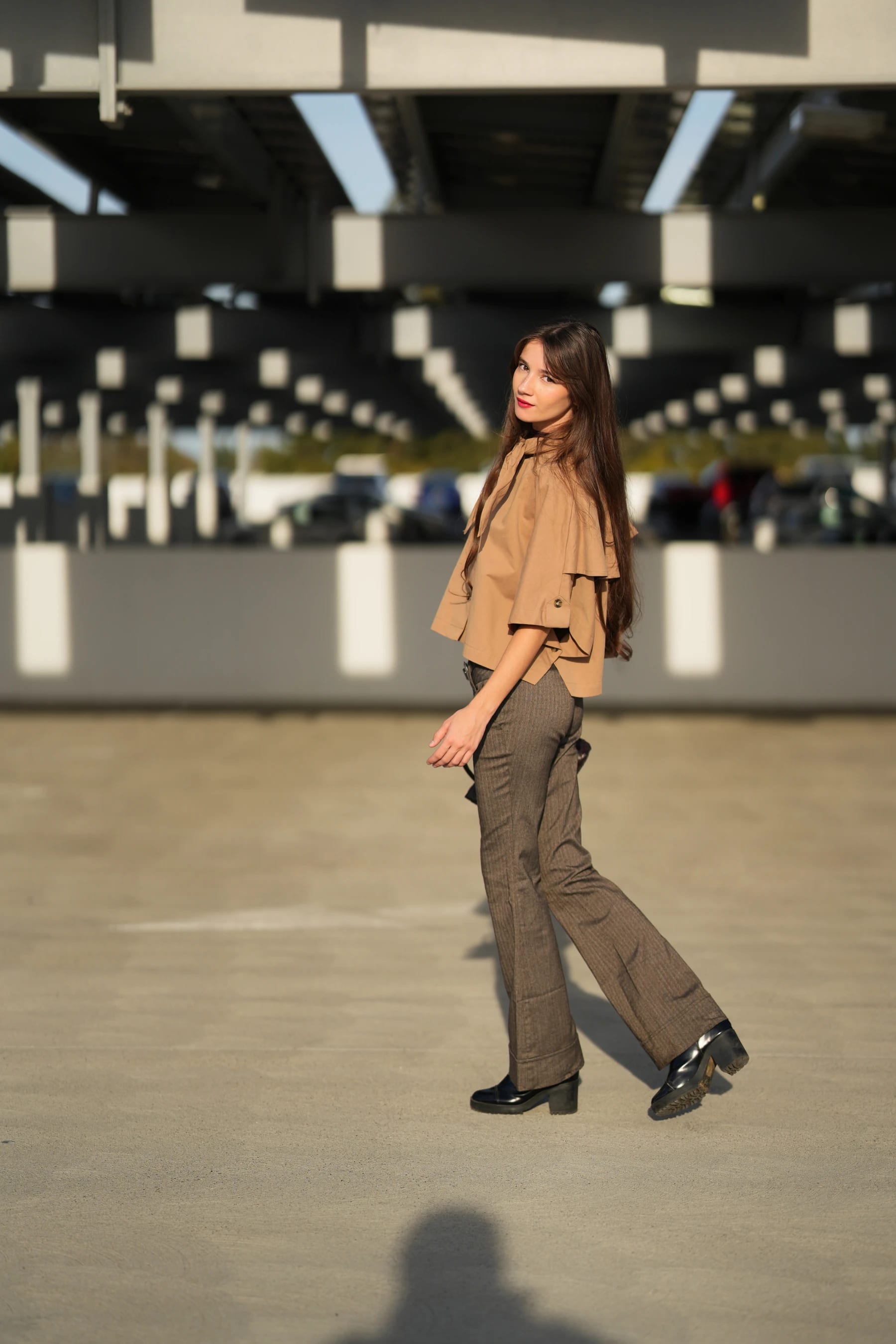 Rosina walking across the garage floor with her bag, looking back over her shoulder — photo B