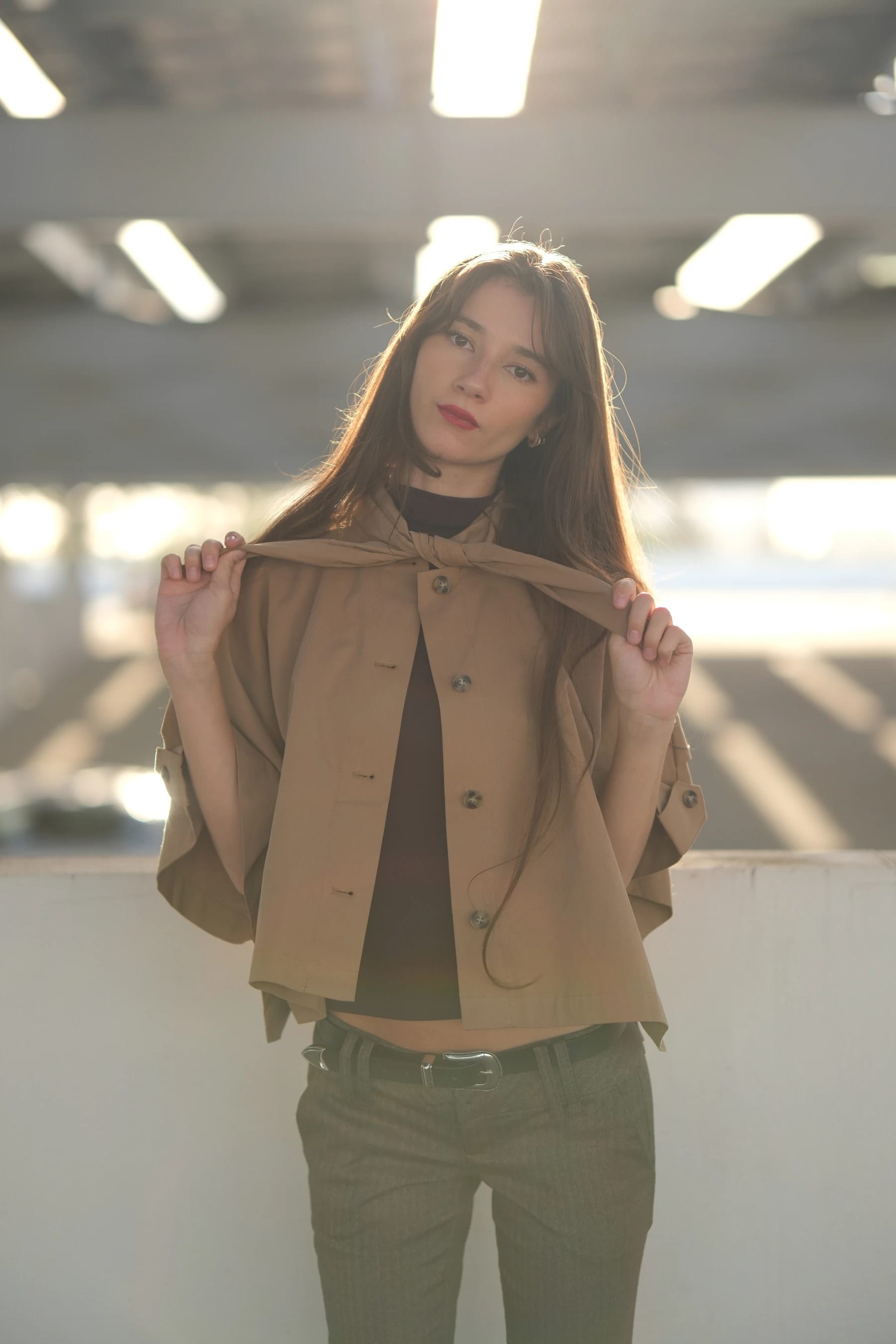 Rosina half body in backlight holding her jacket collar — photo B