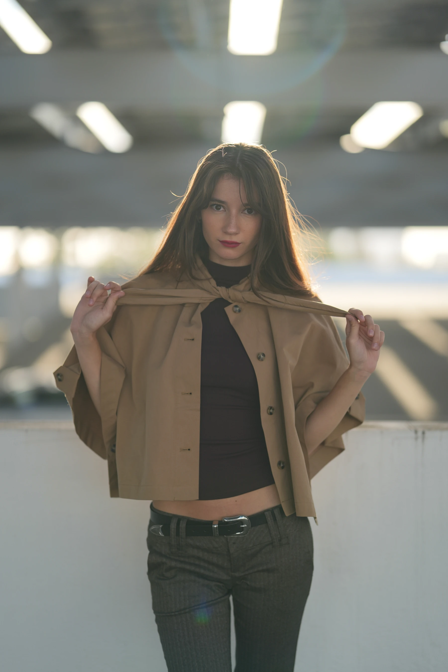 Rosina half body in backlight holding her jacket collar — photo A