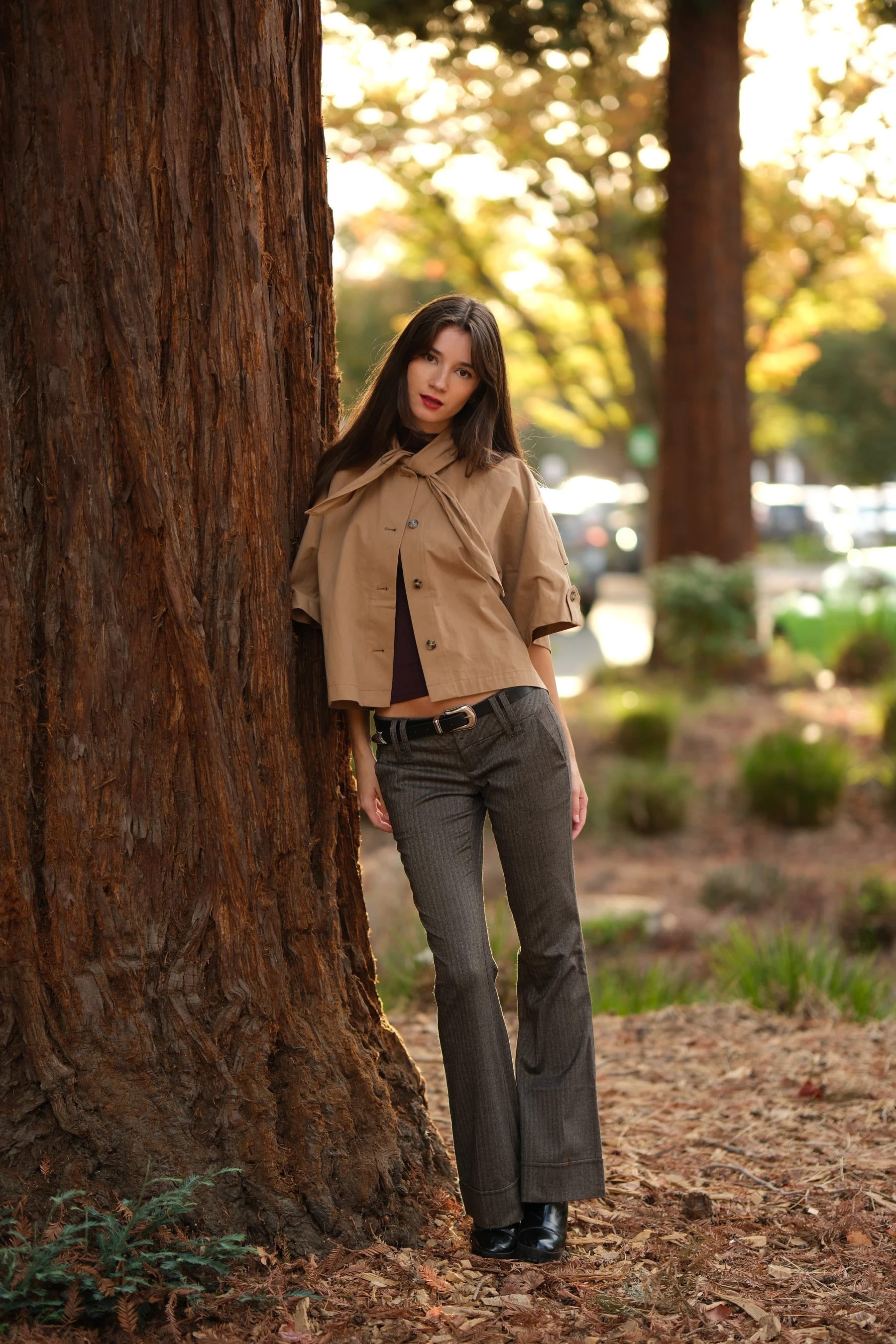 Rosina full length leaning against a redwood — photo B