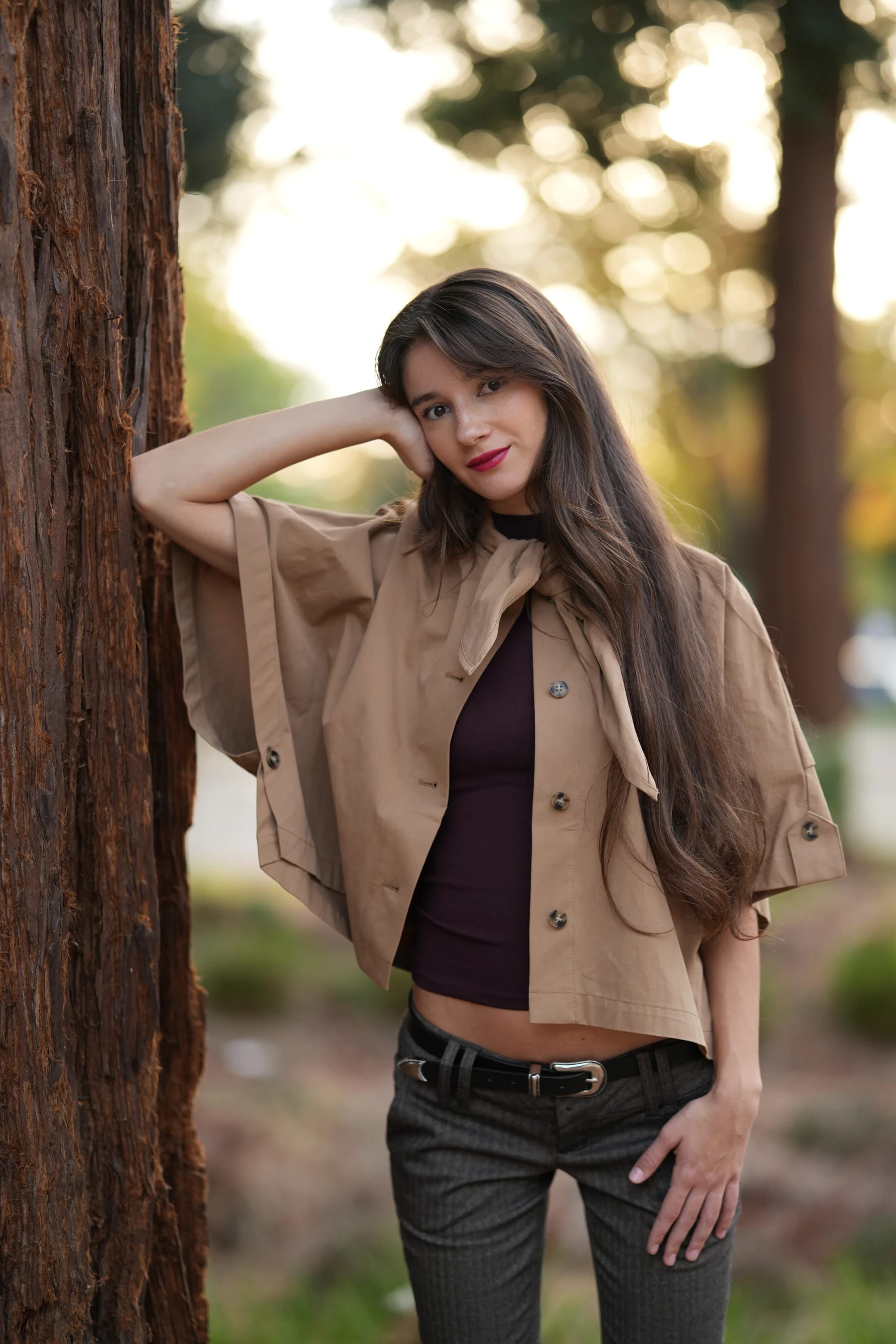 Rosina by a redwood with one hand behind her head — photo A