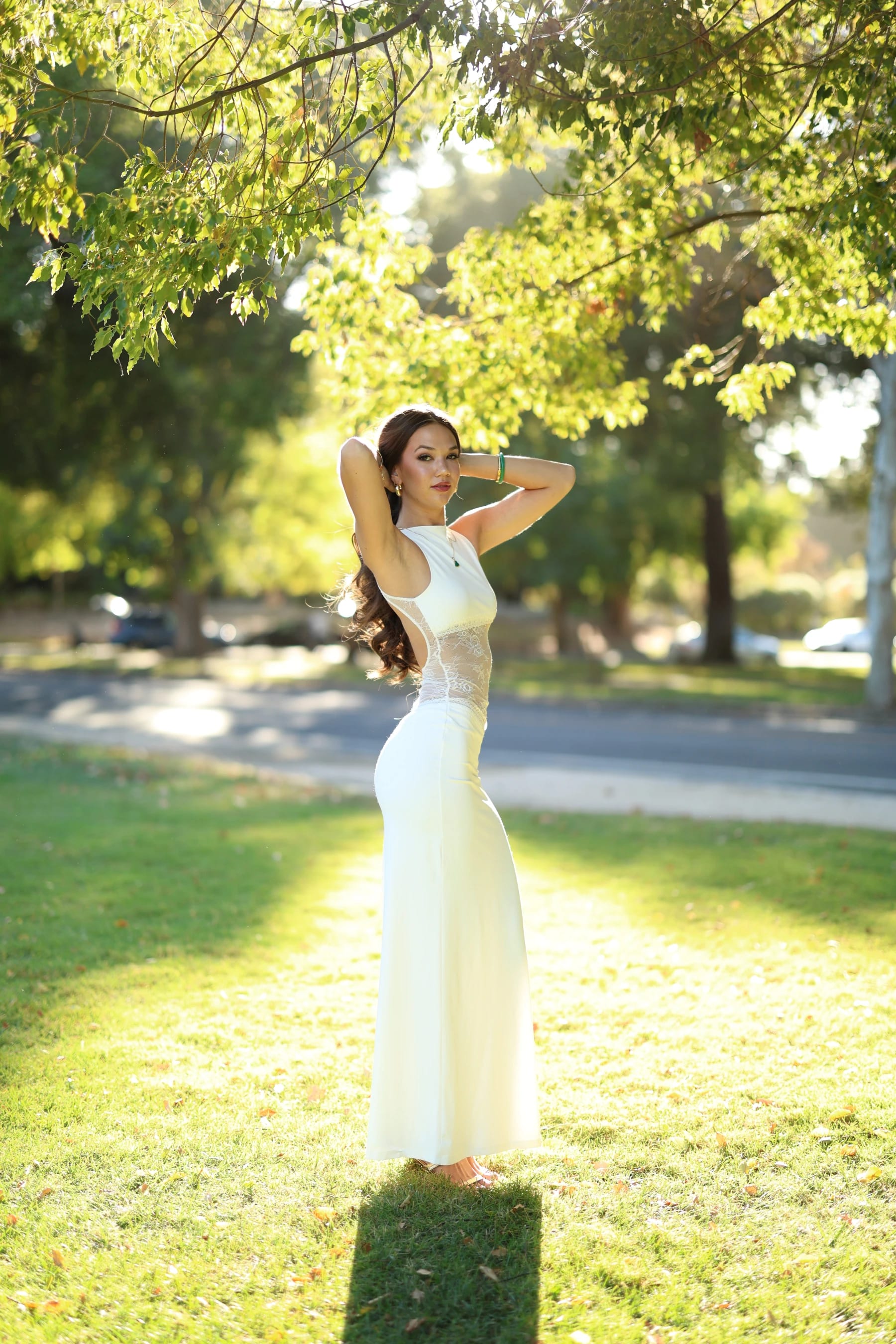 Mia full length, backlit with arms raised and her shadow toward the camera — photo A