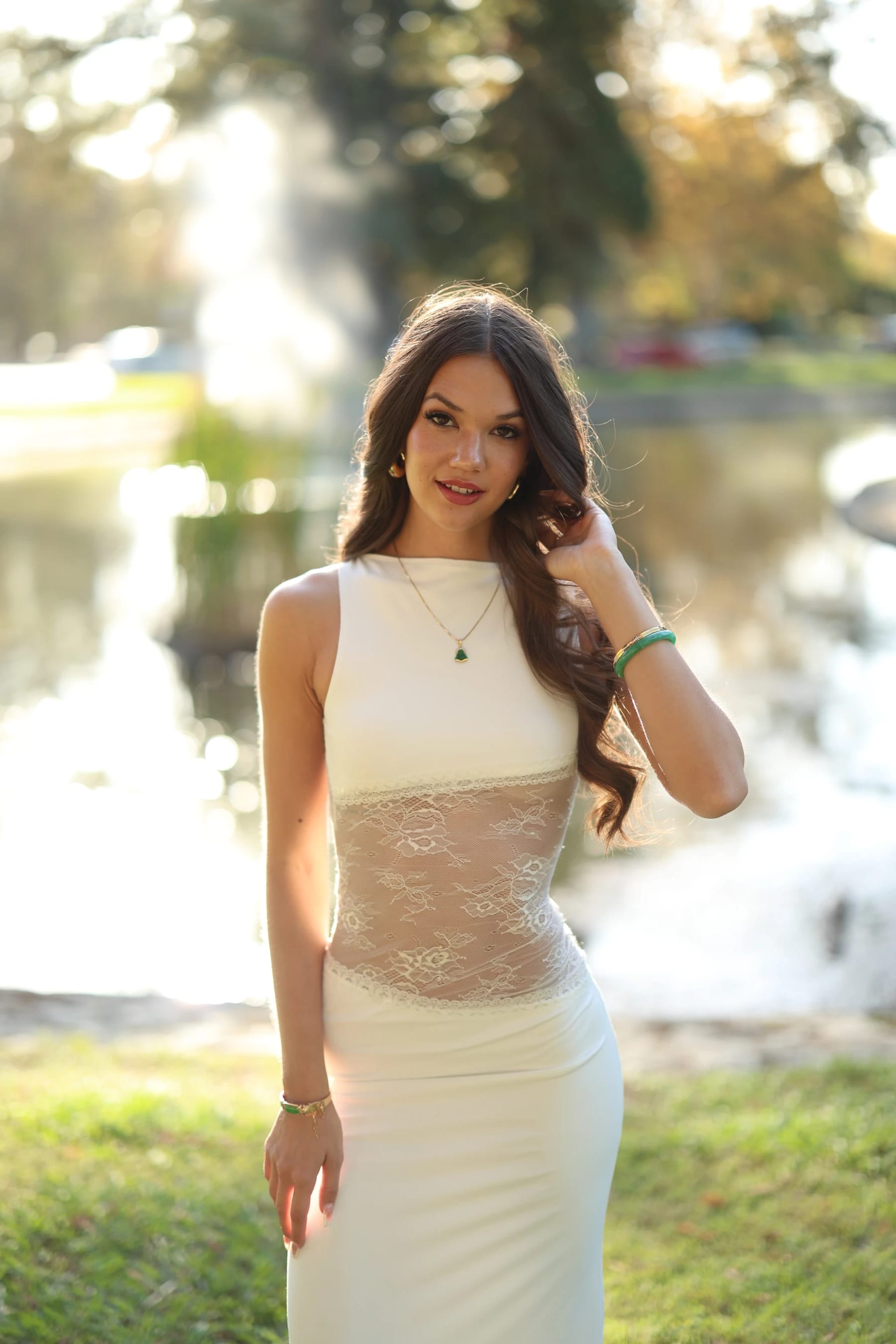 Mia half body in front of the backlit fountain — photo A