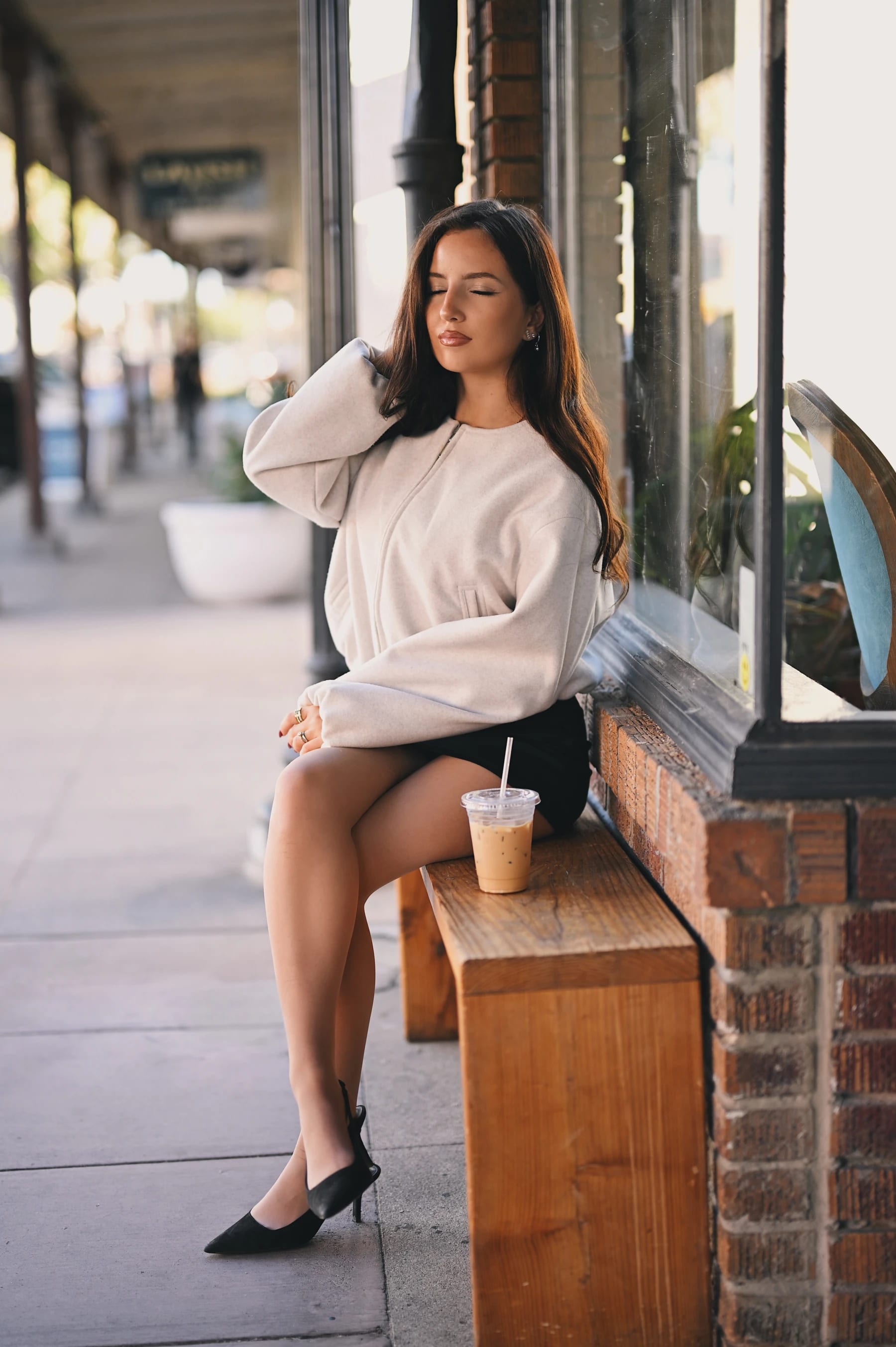 Yasmina sitting pose ideas on a bench outside Fourscore Coffee, Nikon Z6III Nikkor Z 50mm f/1.2 S 1 of 8