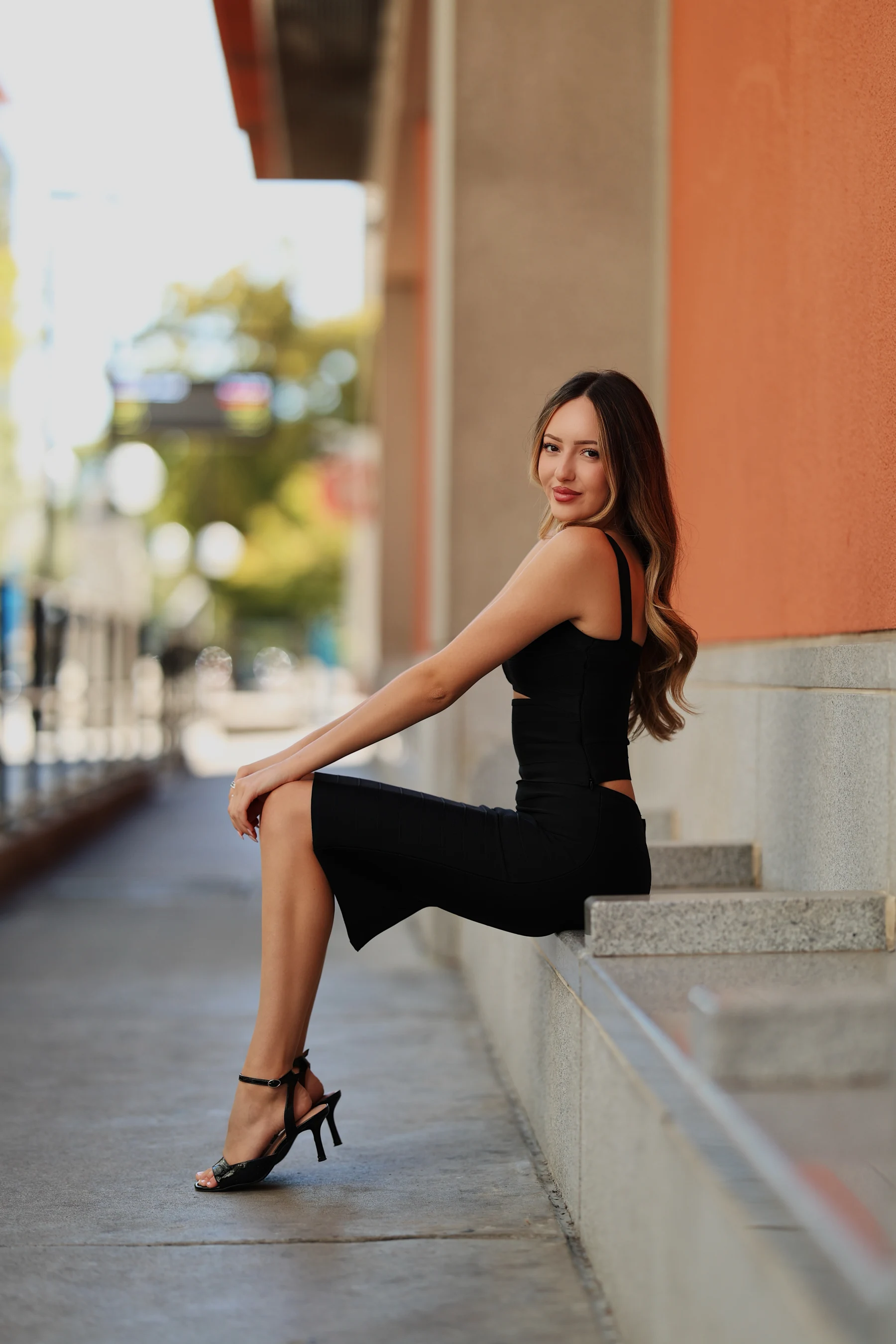 Andrea sitting poses, dynamic side angles, all-black outfit 1 of 5