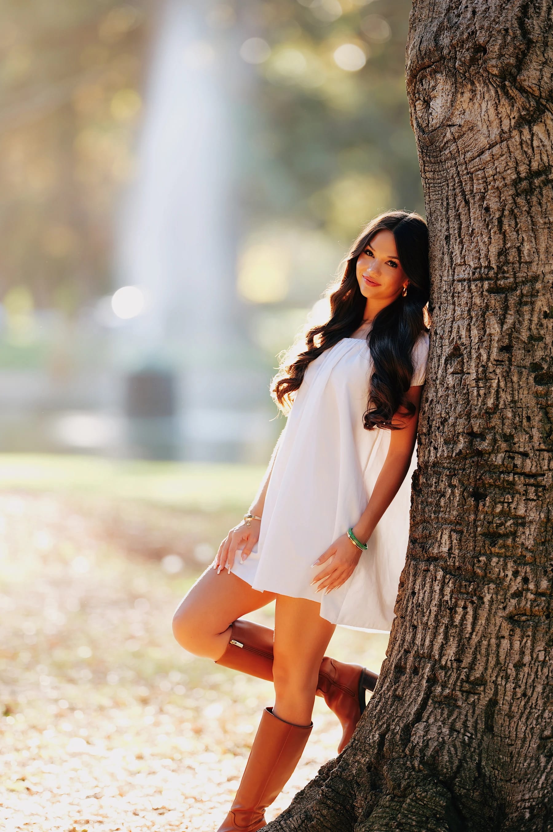 Mia posing against a big tree trunk in William Land Park, backlit portraits at f/1.4, Sigma 135mm F1.4 DG Art on Lumix S5II 1 of 5