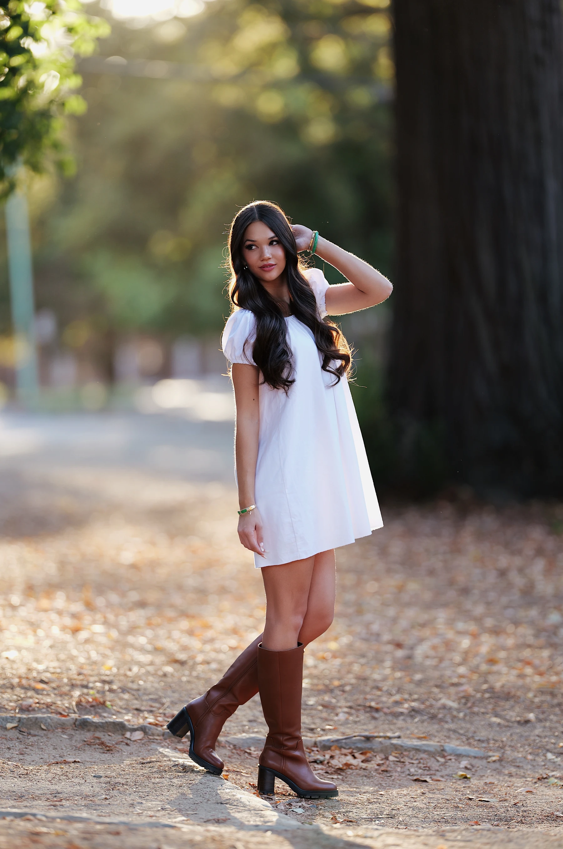Mia full length under tall trees at the end of golden hour in William Land Park, Sigma 135mm F1.4 on Lumix S5II