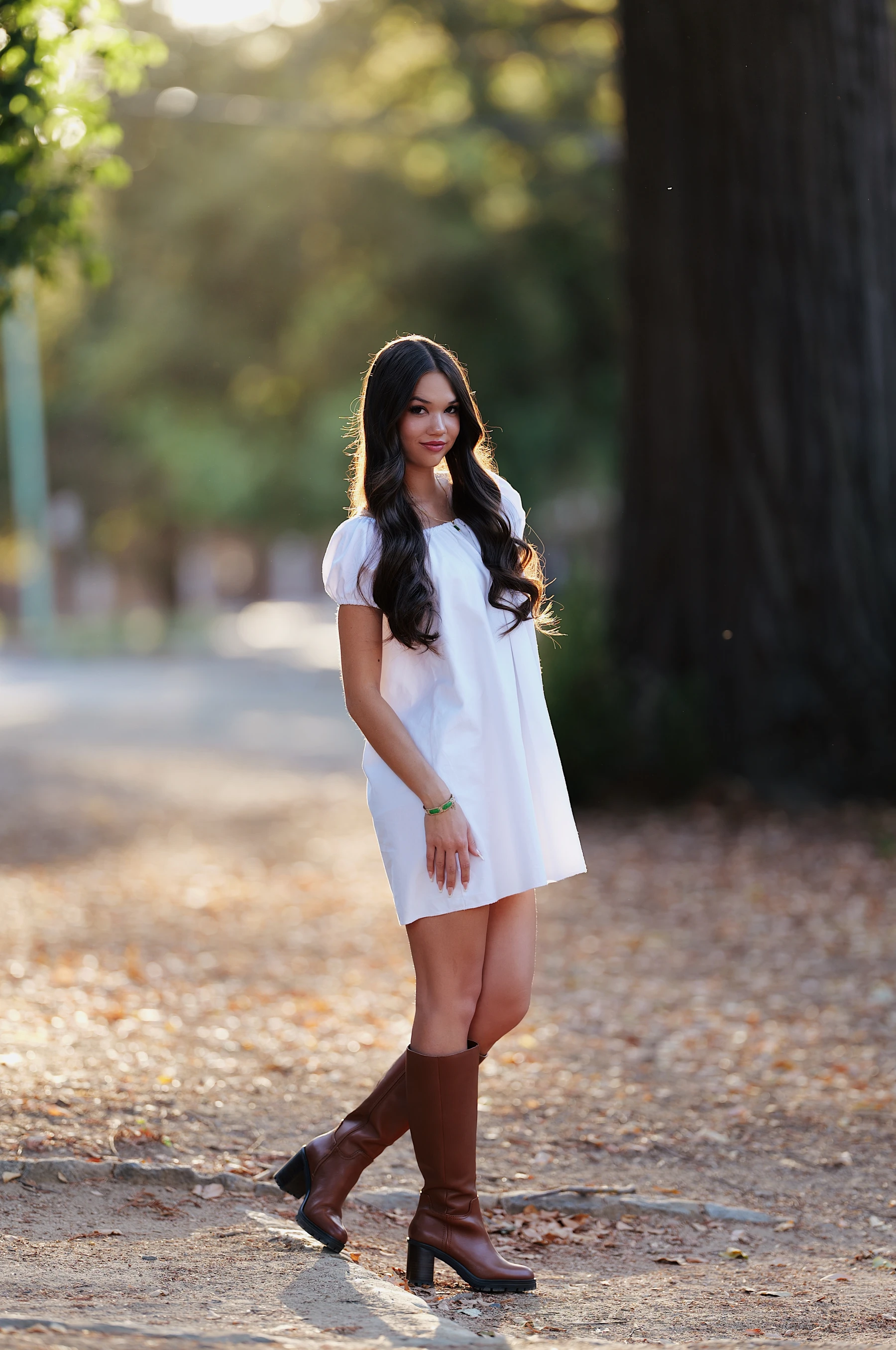 Mia in a white dress and cognac boots on fallen leaves at sunset, Sigma 135mm F1.4 DG Art on Lumix S5II