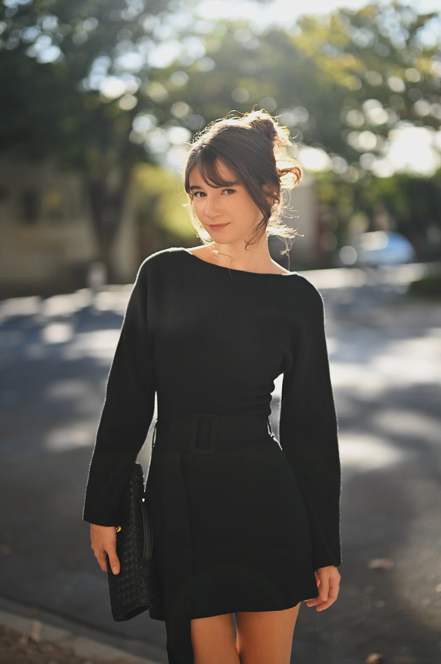 Rosina backlit by the late afternoon sun in a black sweater dress, Midtown Sacramento