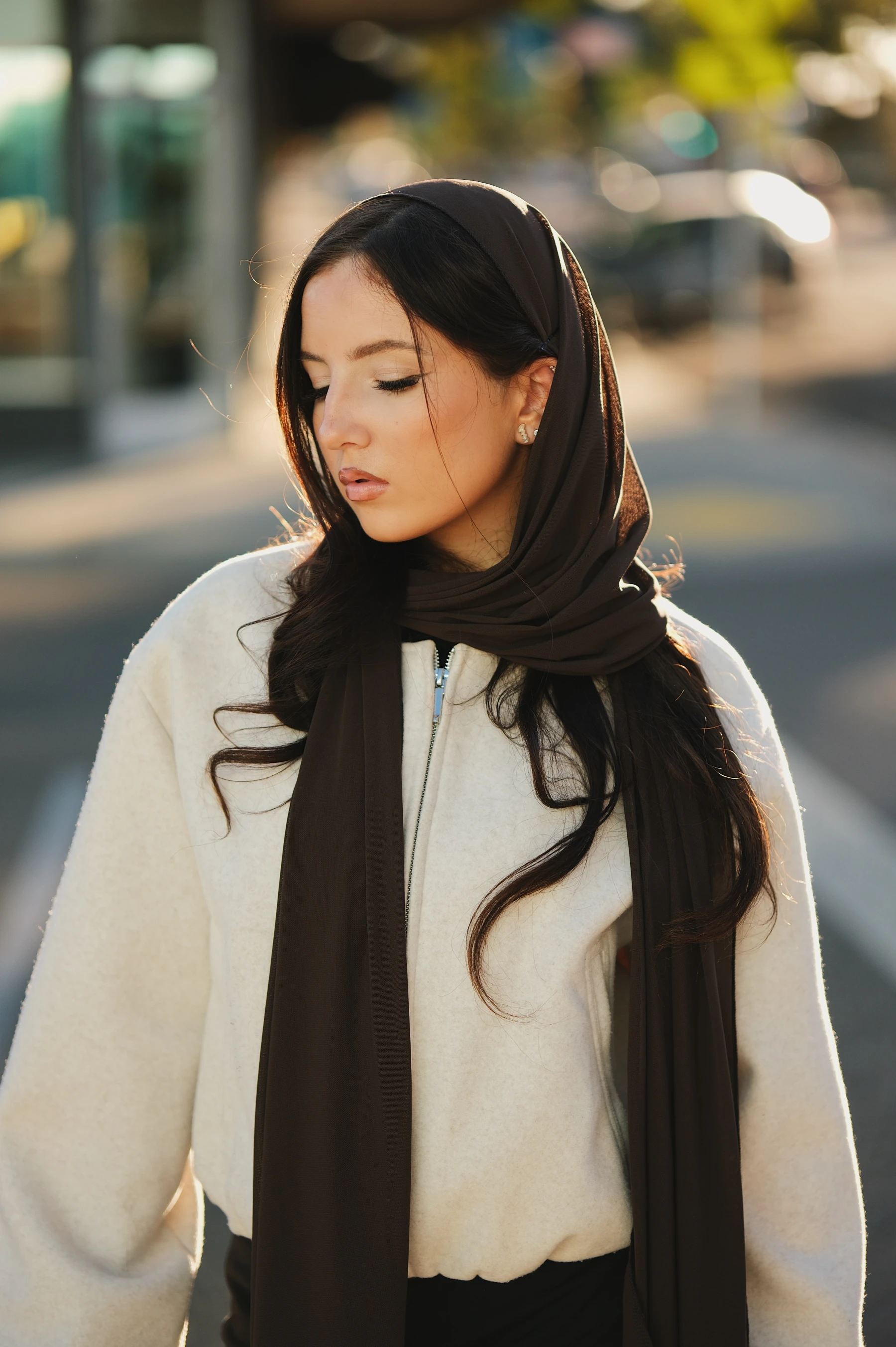 Yasmina with eyes closed and a brown scarf over her hair, close half-body portrait at f/1.2